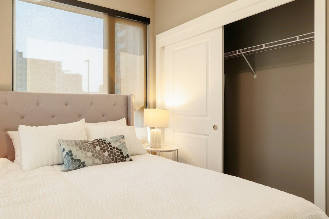 Bedroom with tufted headboard and open closet