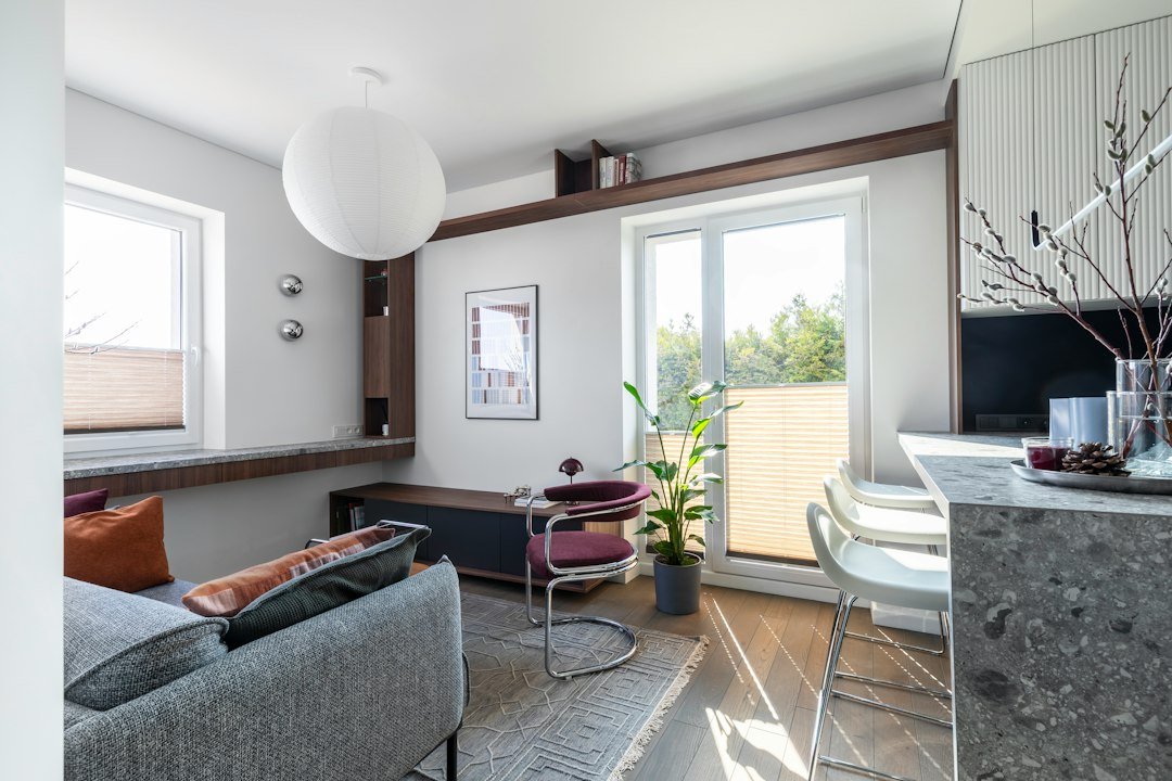 Sunny modern apartment living room with balcony and kitchen counter